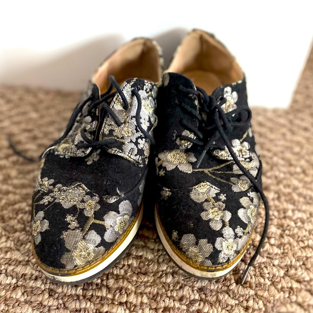 Flat closed toe shoes with flower embroidery.